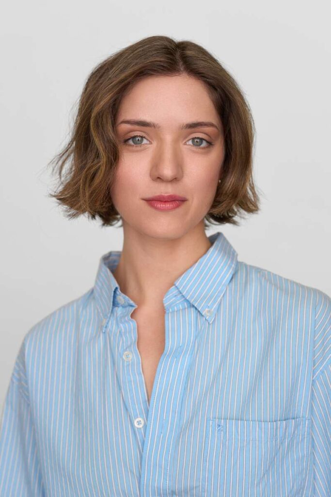 Personne en chemise bleue à rayures, regard neutre.